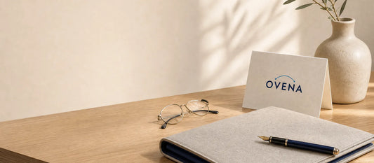 A notebook, glasses, and pen beside an Ovena card