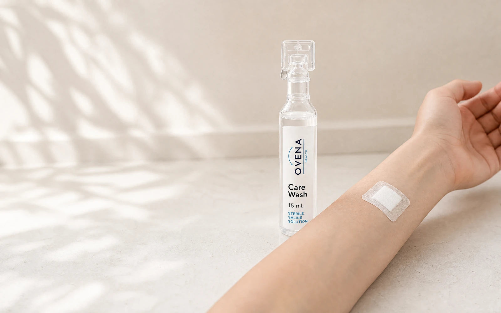 A Care Wash ampoule beside a forearm with a fresh island dressing applied